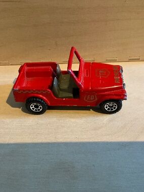 This toy is a vintage red die-cast Jeep